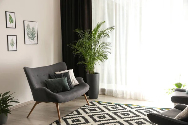 Bekväm soffa nära fönster med eleganta gardiner i rummet — Stockfoto