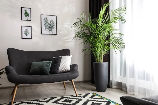 Comfortabele bank in de buurt van raam met elegante gordijnen in de kamer — Stockfoto