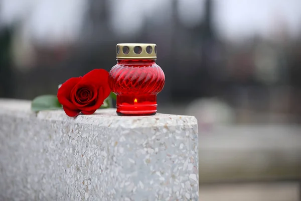 Rose rouge et bougie sur pierre tombale en granit gris clair à l'extérieur. Fu — Photo