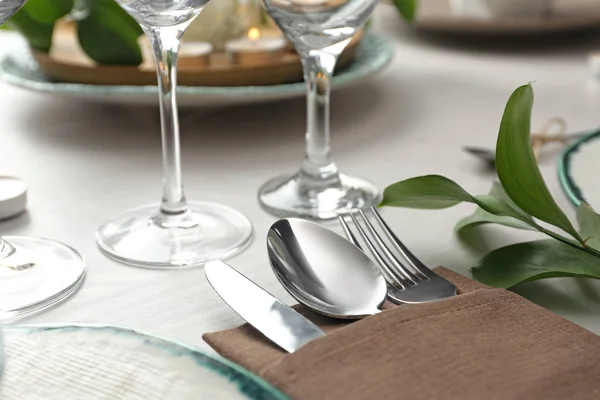 Elegant cutlery with green plant on table, closeup. Festive sett — 스톡 사진