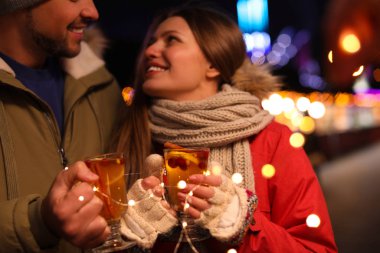 Happy couple with mulled wine at winter fair
