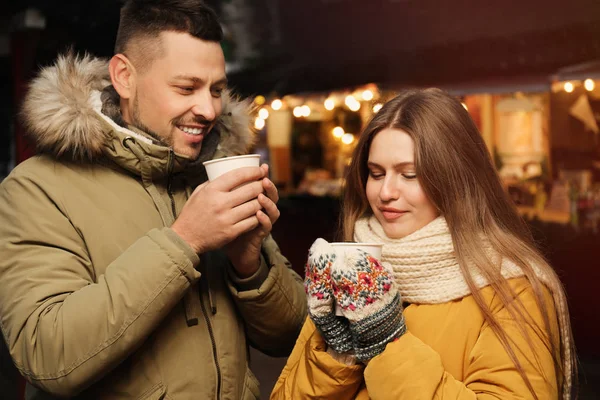 Happy couple with mulled wine at winter fair — Stock Photo, Image