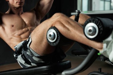 Ayarlanabilir spor yapan adam modern spor salonunda yedek kulübesinde oturur.