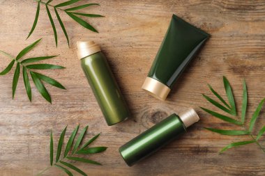 Ahşap masa üzerinde kozmetik ürünleri ile düz kompozisyon yatıyordu