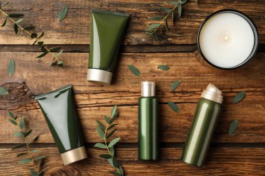 Ahşap masa üzerinde kozmetik ürünleri ile düz kompozisyon yatıyordu