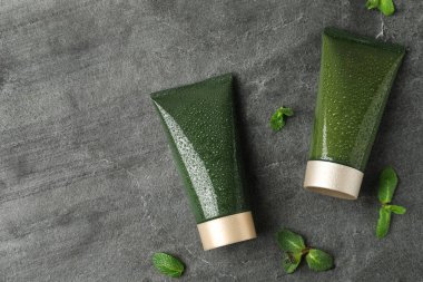 Gri taş zemin üzerinde kozmetik ürünlerle bezenmiş düz bir kompozisyon. Metin için boşluk