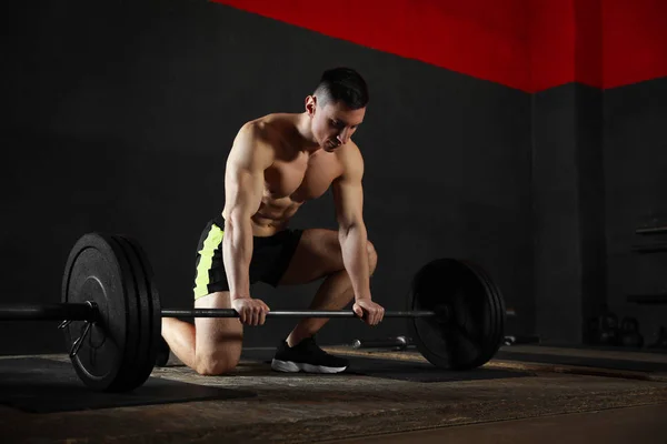 Stark karl som lyfter skivstång i modernt gym — Stockfoto