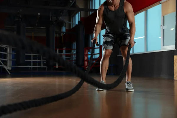 Hombre haciendo ejercicio con cuerdas de batalla en el gimnasio moderno, primer plano —  Fotos de Stock