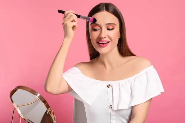 Beauty blogger doing makeup on pink background — Stock Photo, Image