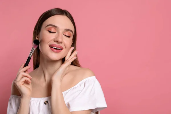 Blogger de belleza haciendo maquillaje sobre fondo rosa. Espacio para texto — Foto de Stock