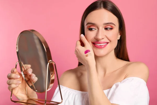 Beleza blogueiro com espelho no fundo rosa — Fotografia de Stock