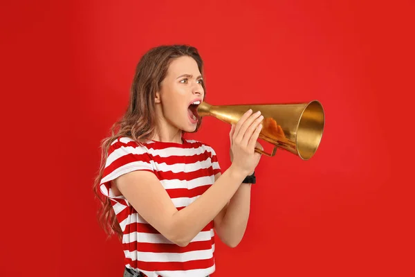 Jovem mulher com megafone no fundo vermelho — Fotografia de Stock