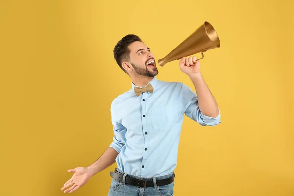 Jovem com megafone no fundo amarelo — Fotografia de Stock