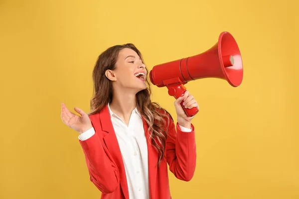 Jovem mulher com megafone no fundo amarelo — Fotografia de Stock