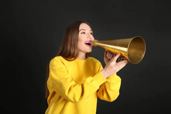 Jovem mulher com megafone no fundo preto — Fotografia de Stock