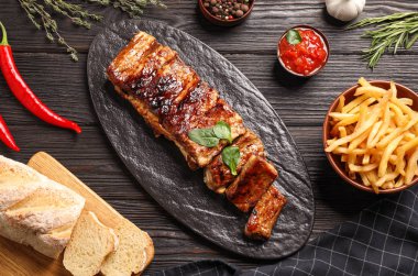 Siyah ahşap masada servis edilen nefis ızgara pirzola.