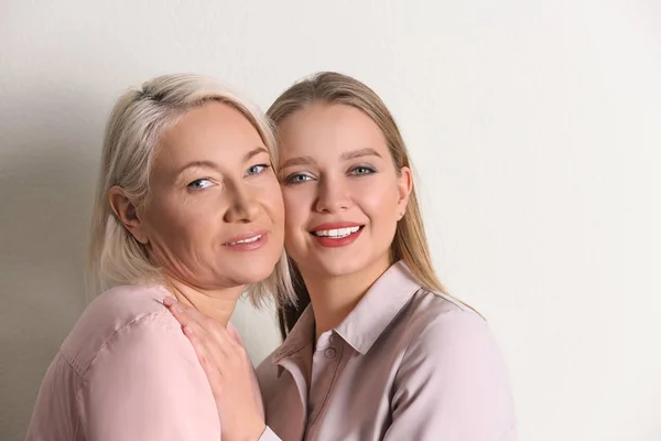 Mãe e sua filha adulta no fundo branco — Fotografia de Stock