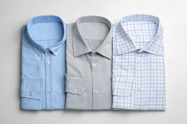 Beyaz arka planda şık erkek gömlekleri, düz yatış