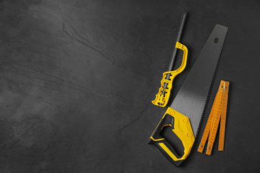 Modern marangoz aletleri siyah arka planda, düz yerde. Metin için boşluk