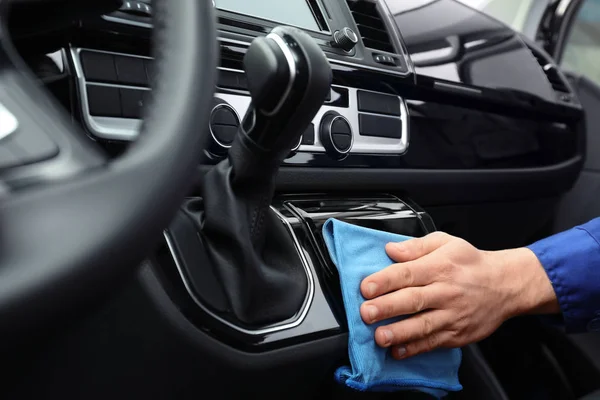 Car wash worker cleaning automobile interior, closeup