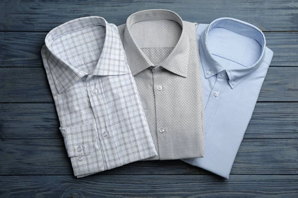 Camisas masculinas con estilo sobre fondo de madera azul, planas — Foto de Stock