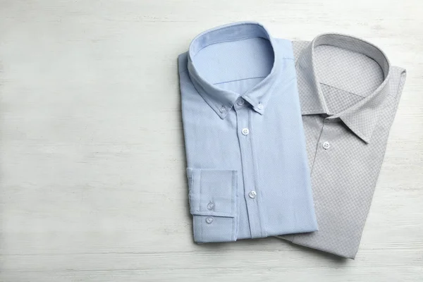 Camisas masculinas con estilo sobre fondo de madera blanca, planas. Espacio — Foto de Stock