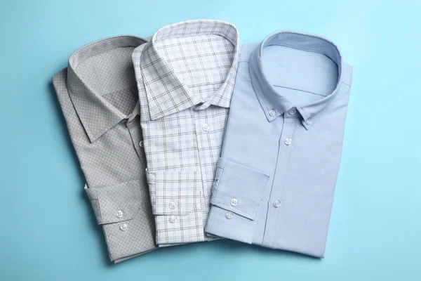 Camisas masculinas con estilo sobre fondo azul claro, planas — Foto de Stock