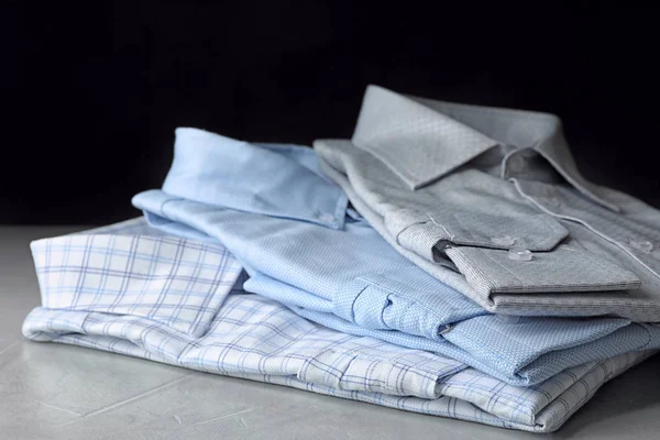 Egy halom klasszikus ing a könnyűkő asztalon. — Stock Fotó