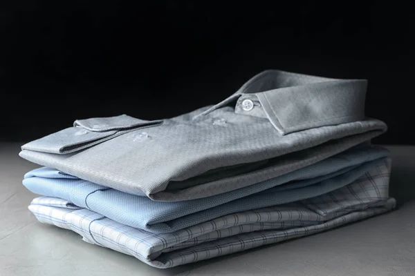 Egy halom klasszikus ing a könnyűkő asztalon. — Stock Fotó