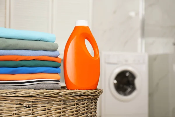 Fresh laundry and detergent on basket in bathroom. Space for tex — Stock Photo, Image