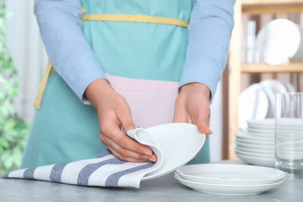 Nő letörli a tiszta tányért az asztalnál, közelkép — Stock Fotó