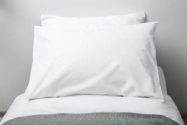 Łóżko z miękkimi puszystymi poduszkami w domu — Zdjęcie stockowe