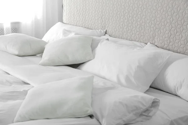 Кровать с мягкими пушистыми подушками дома — стоковое фото