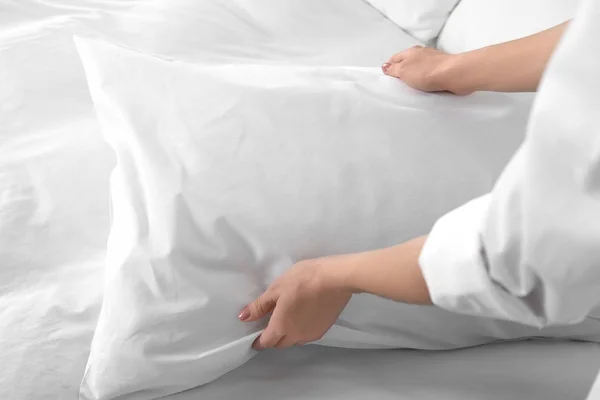 Woman fluffing soft pillow in bedroom, closeup — Stock Photo, Image