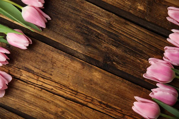 Prachtige roze lente tulpen op houten ondergrond, plat gelegd. Kuuroord — Stockfoto