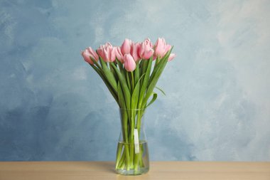 Tahta masadaki vazoda güzel pembe bahar laleleri