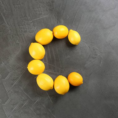 C harfi, gri masadaki limonlarla vitamin oranı olarak yapılır.
