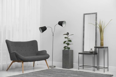 Beyaz duvarın yanındaki modern ayna şık oturma odasında.