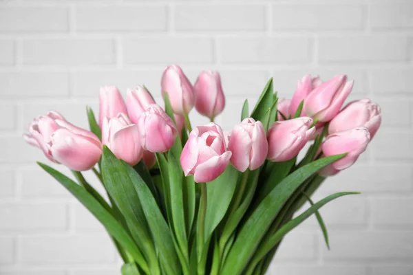 Bonitas tulipas de primavera rosa no fundo de tijolo branco — Fotografia de Stock