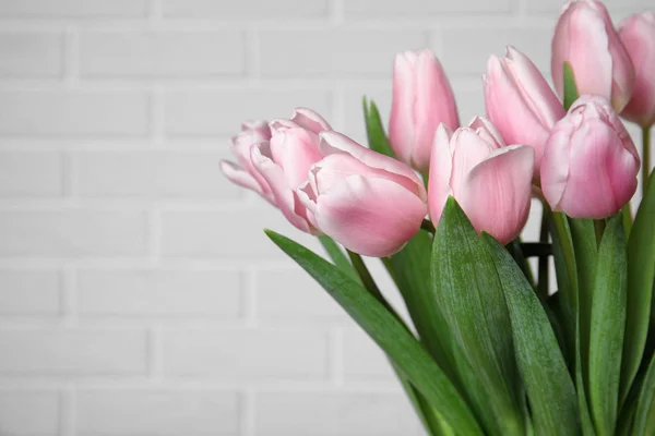 Hermosos tulipanes de primavera rosa cerca de la pared de ladrillo blanco, primer plano. Spa — Foto de Stock