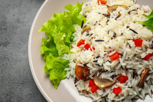 Delicious rice pilaf with mushrooms on grey table, closeup — Stock Photo, Image