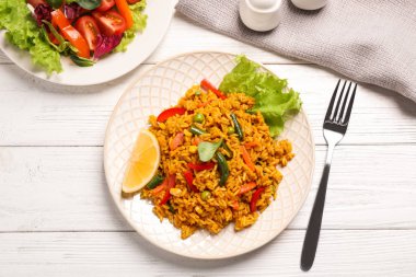 Beyaz ahşap masada sebzeli leziz pirinç pilavı.