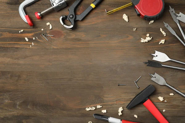 Composição de leigos planos com ferramentas de carpinteiro em fundo de madeira — Fotografia de Stock