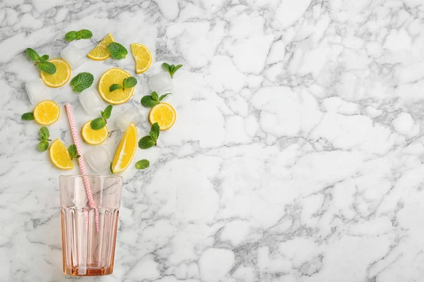 Творче компонування лимонаду зі скибочками лимона, м'ятою та льодом на білому — стокове фото