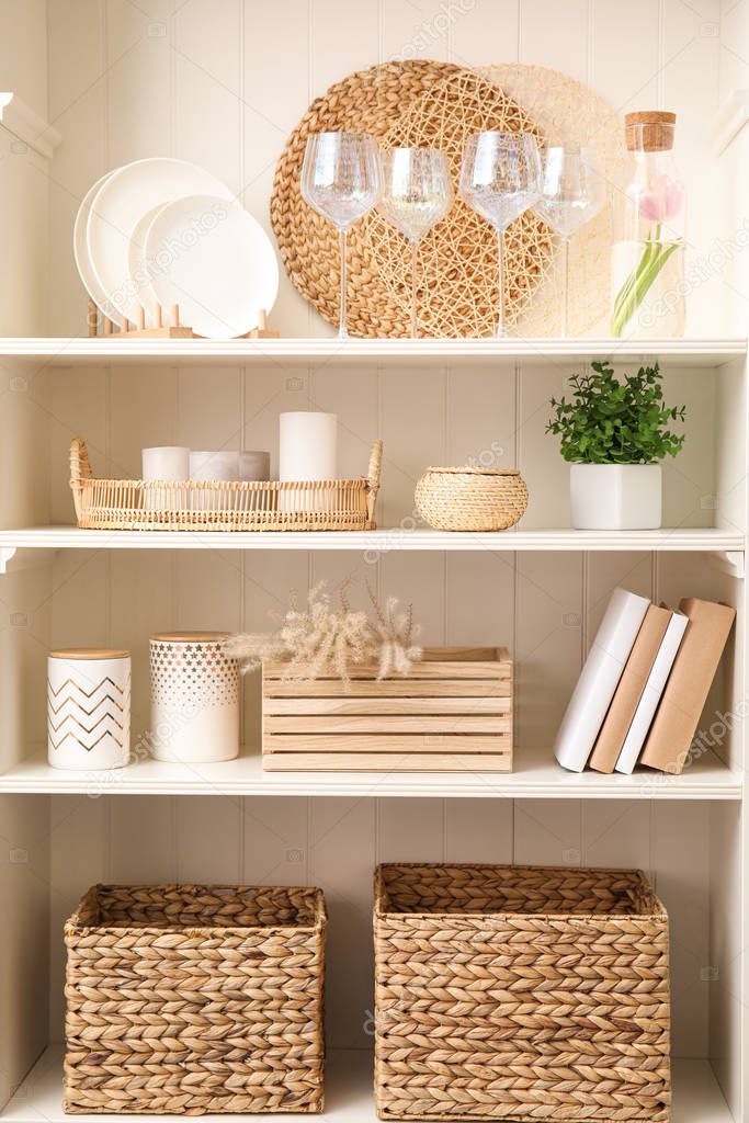 White shelving unit with dishware and different decorative stuff