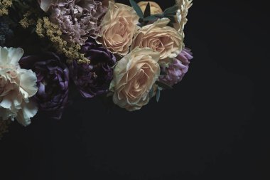 Siyah arka planda farklı çiçeklerden oluşan güzel bir buket, metin için yer. Çiçek kart tasarımı koyu renkli efekt