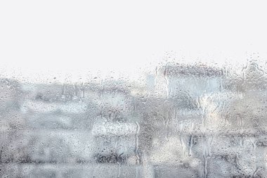Yağmurlu bir günde pencereden şehrin bulanık görüntüsü