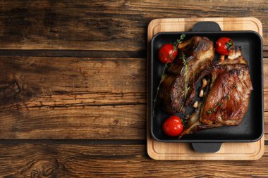 Delicious roasted ribs served on wooden table, top view. Space for text