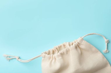 Cotton eco bag on light blue background, top view. Space for text