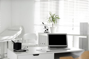 Doctor's workplace with laptop in modern clinic